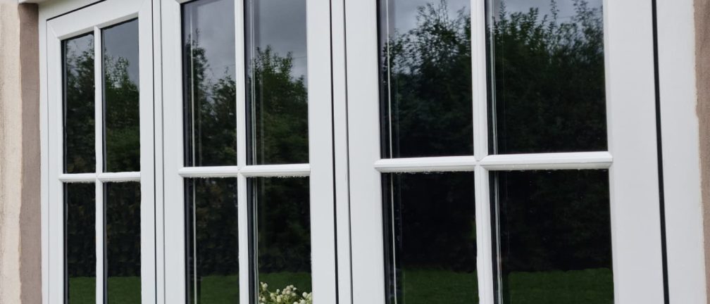 White flush casement windows with astragal bars.