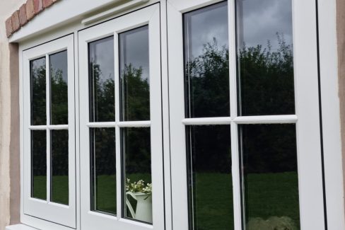 White flush casement windows with astragal bars.